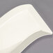 A white rectangular Fineline Wavetrends plastic salad plate with a curved edge.