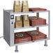 A Hatco Glo-Ray heated shelf on a counter with pizza boxes and brown bags.