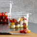 A clear polycarbonate food pan with tomatoes and mozzarella.