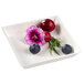 A white square Solia quartz plate with blueberries and purple flowers.