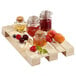 A group of jars of jam and fruits on a Solia wooden tray pallet.
