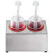 A Steril-Sil stainless steel condiment dispenser kit with red pump lids on a stand.
