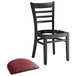 A Lancaster Table & Seating black wood ladder back chair with a burgundy vinyl seat