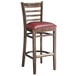 A Lancaster Table & Seating wooden ladder back bar stool with a burgundy vinyl seat.