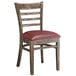 A Lancaster Table & Seating wooden ladder back chair with a burgundy vinyl seat