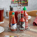 An American Metalcraft stainless steel condiment caddy holding hot sauce bottles on a table.