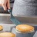 A person using a grey Linden Sweden Gourmaid silicone spatula to flip a pancake.