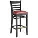 A Lancaster Table & Seating black wood ladder back bar stool with a burgundy vinyl seat.