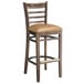 A Lancaster Table & Seating wood bar stool with light brown vinyl seat detached.