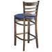 A Lancaster Table & Seating wooden ladder back bar stool with a navy vinyl seat