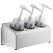 A Steril-Sil stainless steel 3-compartment pump condiment dispenser on a counter with black and white containers.