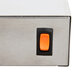 An orange rectangular switch on a metal box.