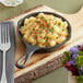 A Lodge mini cast iron skillet of macaroni and cheese with a fork.