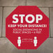 A red E-Z Up octagon floor decal with white text reading "Keep Your Distance" and people icons.