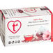A box of Wild Hibiscus Heart-Tee Hibiscus Herbal Tea Bags with a glass of red tea on the label.
