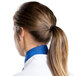 A woman in a white chef coat with a royal blue Intedge neckerchief tied around her ponytail.