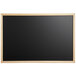A black wall-mount chalkboard with a wood frame.