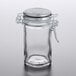 A Tablecraft clear glass condiment jar with a stainless steel lid and bail and trigger closure.