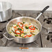 A Vollrath saute pan of shrimp and vegetables on a stove.