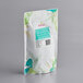 A white Bossen tea bag with green and blue designs and green leaves.