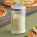 An American Metalcraft glass beehive cheese shaker with a stainless steel lid filled with white powder.