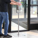 A man using a Steril-Sil hand sanitizer floor stand in a corporate office cafeteria.