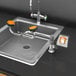 A Guardian Equipment deck mounted sink with a faucet and orange handle.