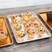 A Chicago Metallic bakery display tray with muffins, some with chocolate chips on top.