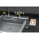 A Guardian Equipment stainless steel deck mounted eyewash station with a faucet over a sink with a hand wash sign.