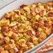 A casserole dish with bread stuffing and cheese topped with Regal Ground Savory Leaves.