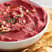 A bowl of red beet hummus with chips made using Regal Beetroot Powder.