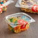 A clear plastic Choice hinged deli container filled with gummy bears and nuts.