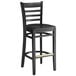 A Lancaster Table & Seating black wood ladder back bar stool with black wood seat.