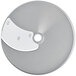 A silver circular metal disc with holes.