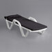 A white Lancaster Table & Seating chaise lounge with black cushion and pillow.