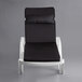 A white Lancaster Table & Seating chaise with a black cushion and pillow