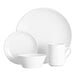 A group of Acopa Bright White coupe dinnerware including plates and cups.