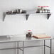 A Regency stainless steel solid wall shelf above a counter with food items on it.
