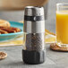 An OXO Good Grips pepper mill on a table with food and a glass of orange juice.