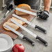 A man using a Schraf serrated knife to slice bread on a cutting board.
