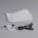 A stack of plastic bags with a black cord and a black plug for a VacPak-It Ultima vacuum packing machine.