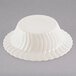 A white Fineline Flairware plastic bowl with wavy edges.