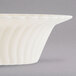 A Fineline Flairware ivory plastic bowl with a wavy design.