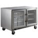 A Beverage-Air stainless steel undercounter freezer with glass doors on wheels.