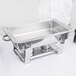 A Vollrath stainless steel water pan inside a chafer on a counter.