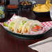 An oval white polypropylene server filled with tacos.