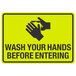 A black and yellow aluminum sign that says "Wash Your Hands Before Entering" with symbols of hands washing.