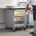 A man in a commercial kitchen putting food into a Beverage-Air undercounter freezer.