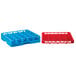 A red plastic Carlisle glass rack with blue and red compartments.