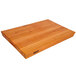 A John Boos cherry wood cutting board with hand grips.
